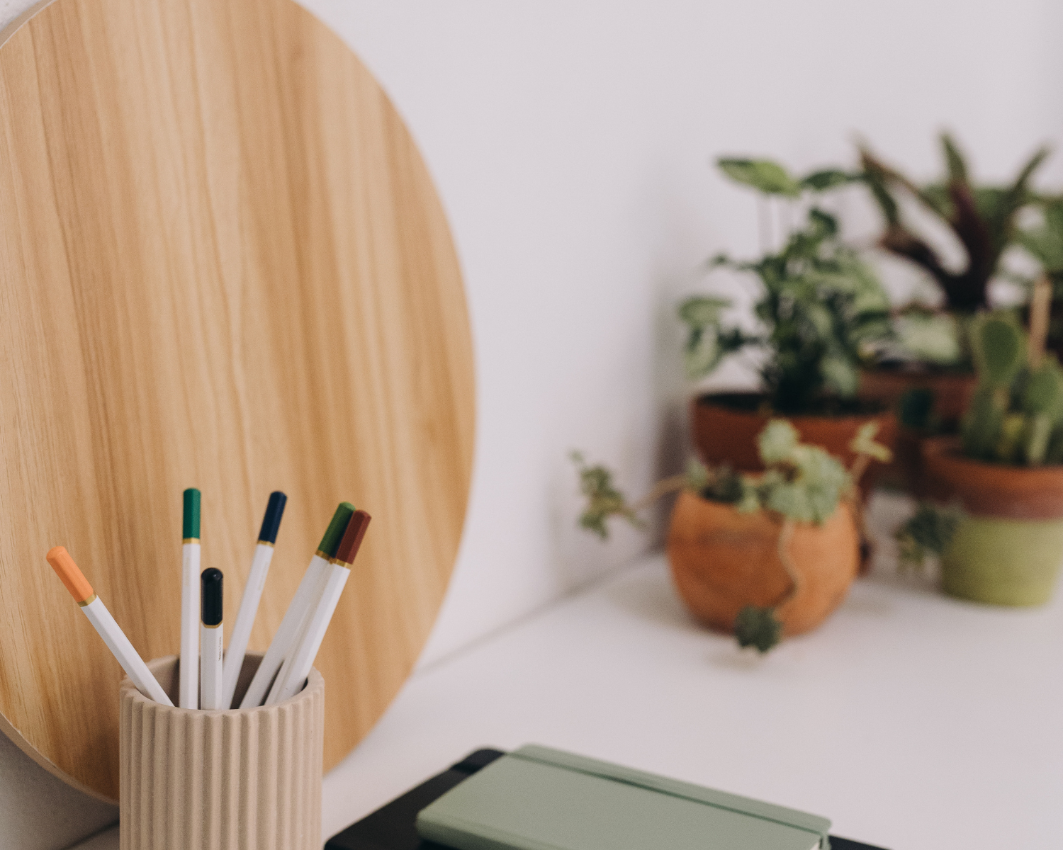 The Right Way to make changes to a contract - Image of green notebook with a mug of pens against a white backdrop